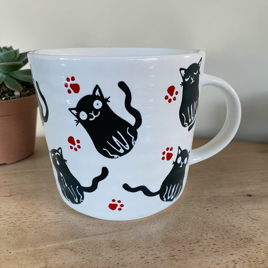 Playful Black Cat & Red Pawprints Coffee Mug