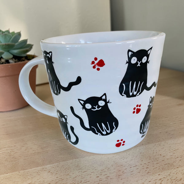 Playful Black Cat & Red Pawprints Coffee Mug